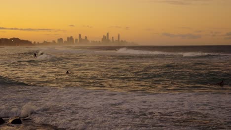 Surf-Al-Atardecer---Surfistas-Montando-Olas-Durante-La-Puesta-De-Sol-Dorada-En-La-Costa-Dorada,-Australia---Paraíso-De-Los-Surfistas