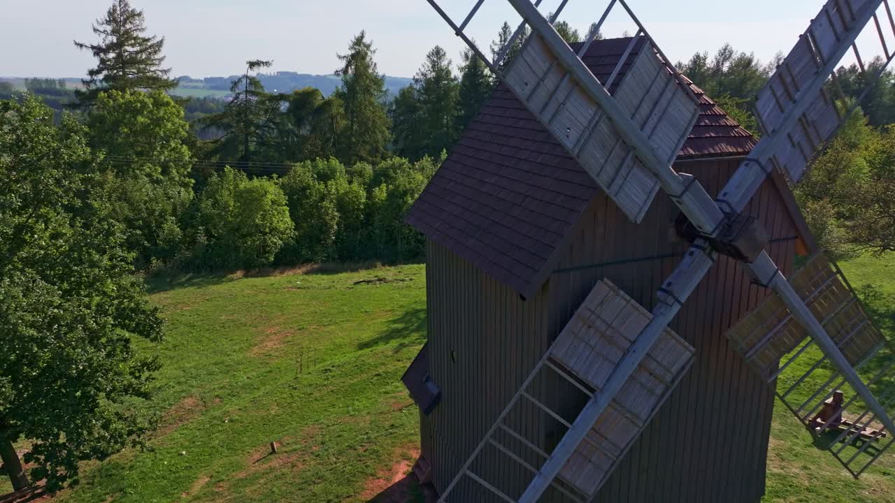Luftpanorama af en vindmølle, der står i et uendeligt grønt landskab