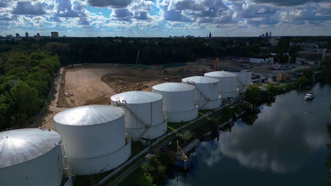 boat on river Decommissioning of Storage depot for petroleum products storage silos and containers. Industrial storage tanks holding oil and gas products. Majestic aerial view flight descending drone