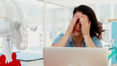 female executive enjoying breeze from table fan 4k