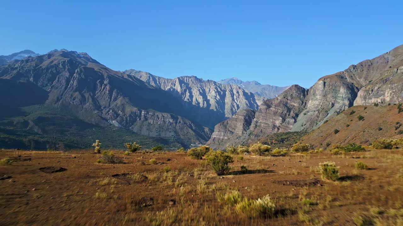 Sfocatura da movimento in avanti con inclinazione verso il basso che rivela una valle arida. Cajón del Maipo, Cile.