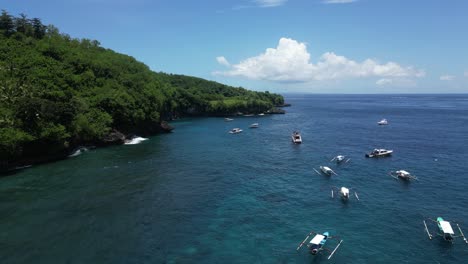 Blue-sea-with-many-boats-on-a-sunny-day-and-forest-scenery-on-land