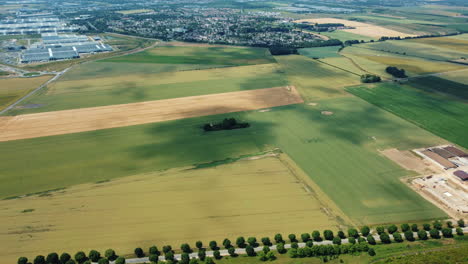 aerial view of rural landscape with fields, town, and industrial area