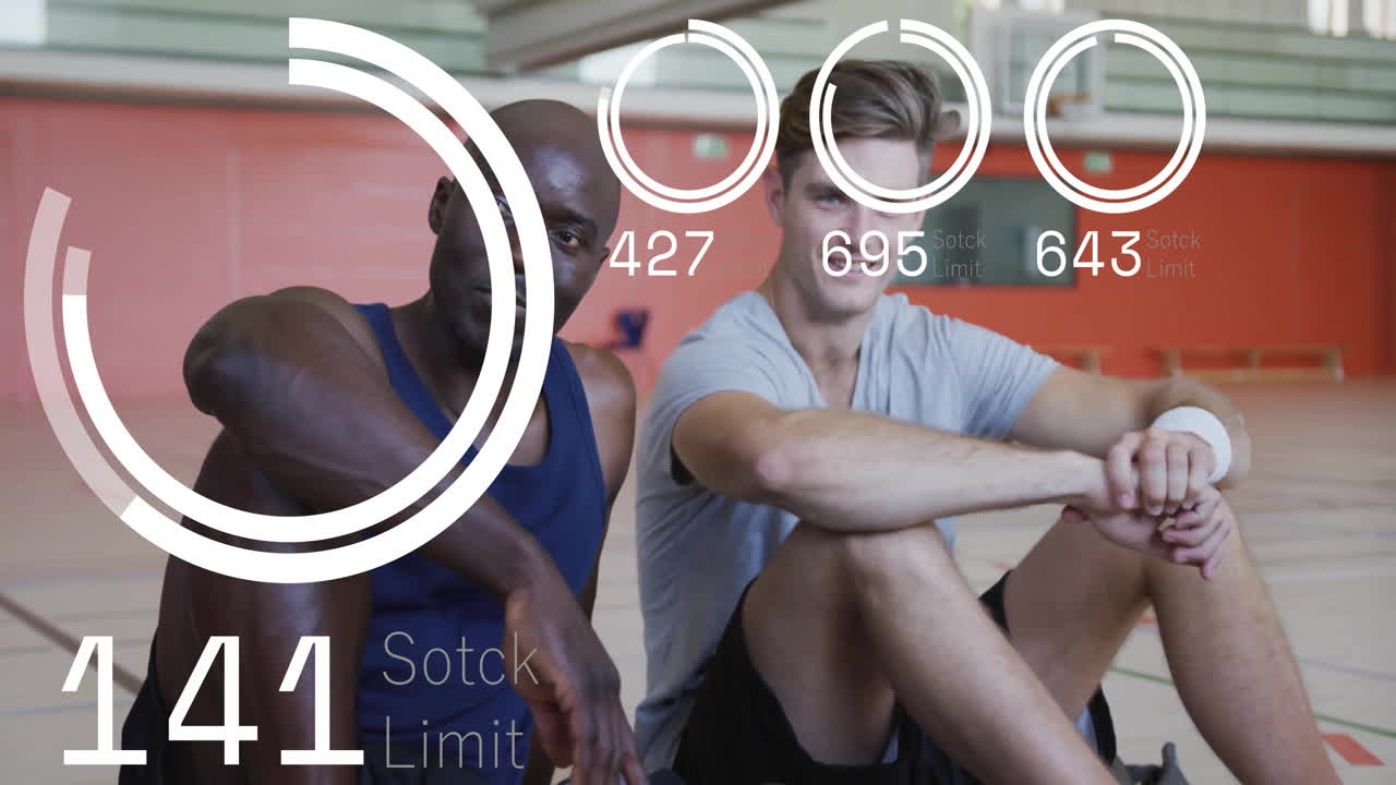 Two men sitting on gym court showing sports tech overlay with stock limit graphics and numbers