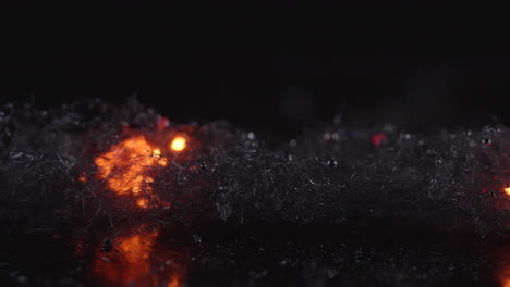 fire spreads rapidly through steel wool against black background