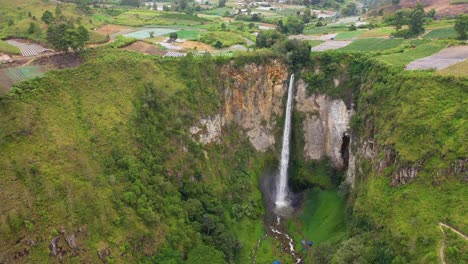 aerial view of sipiso piso waterfall and colourful fields in north sumatra, indonesia