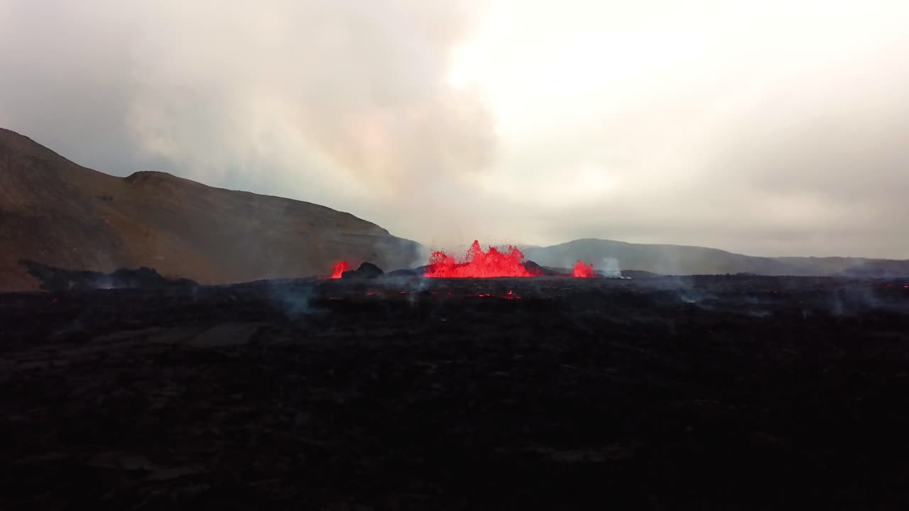 vista aérea ascendente de magma y lava en erupción en el valle de meradalir, del volcán fagradalsfjall, con humo saliendo