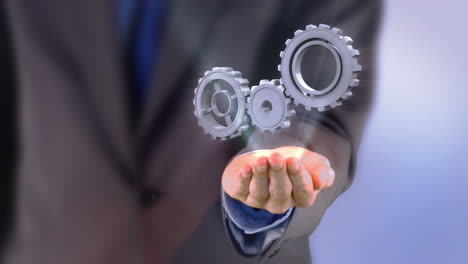 businessman presenting cogs and wheels graphic