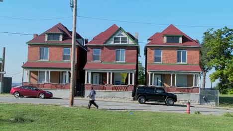 three tenement houses stand together in an urban section of the city