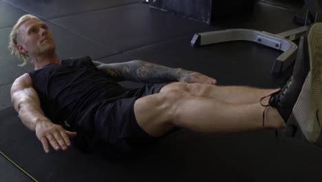 hombre musculoso en el gimnasio en casa haciendo ejercicio v sit hold ab entrenamiento