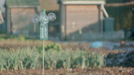 handcrafted wind turbine spinning in a vegetable garden