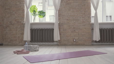 old woman sitting on yoga mat at home