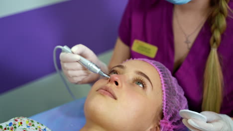 beautician provides beauty manipulations with client`s face. anti aging procedures. beauty clinic.