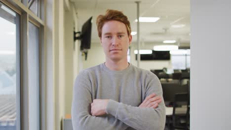 portrait of caucasian creative businessman with crossed hands looking at camera and smiling