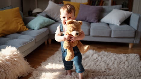 baby playing with teddy bear in the living room