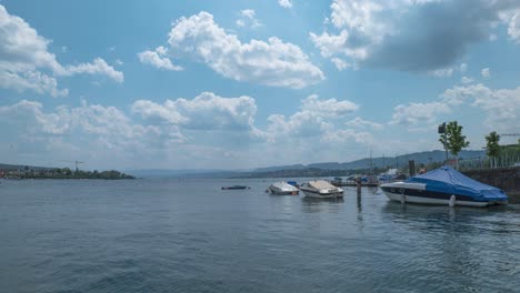 Covered-Boats-Floating-On-Calm-Waters-Of-Lake-Zurich-In-Switzerland