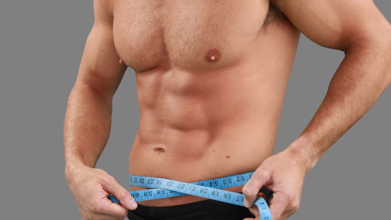 hombre musculoso midiendo su cintura