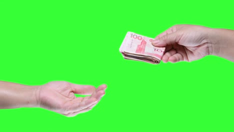 mano con un billete de cien dólares de hong kong aislado en el fondo de la pantalla verde.