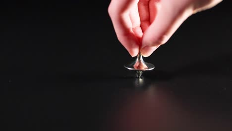 hand spinning a top on a surface