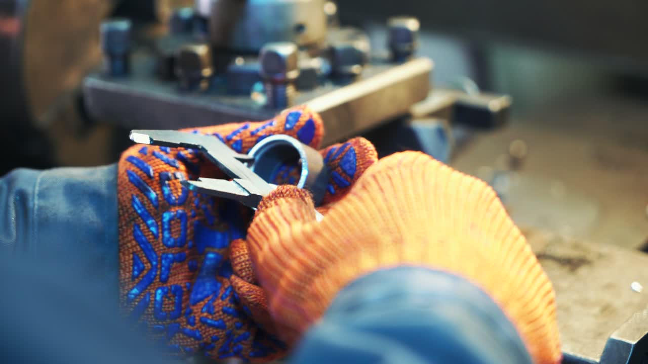 Worker professionally measuring the shaped material on lathe