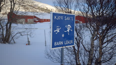 drive slow children at play road sign in norwegian with a winter backdrop