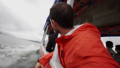 joven viajero caucásico de pie en un barco turístico cruzando un lago natural en costa rica centroamérica naturaleza salvaje