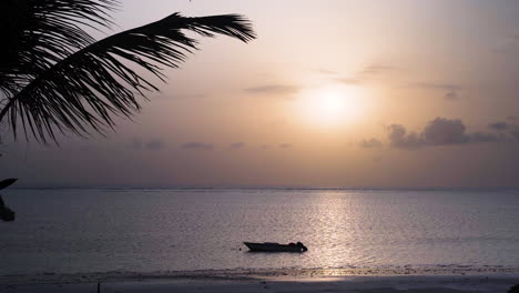 Motorboot-Vor-Anker-Am-Tropischen-Strand-Bei-Sonnenuntergang,-Palmenblätter-Im-Wind