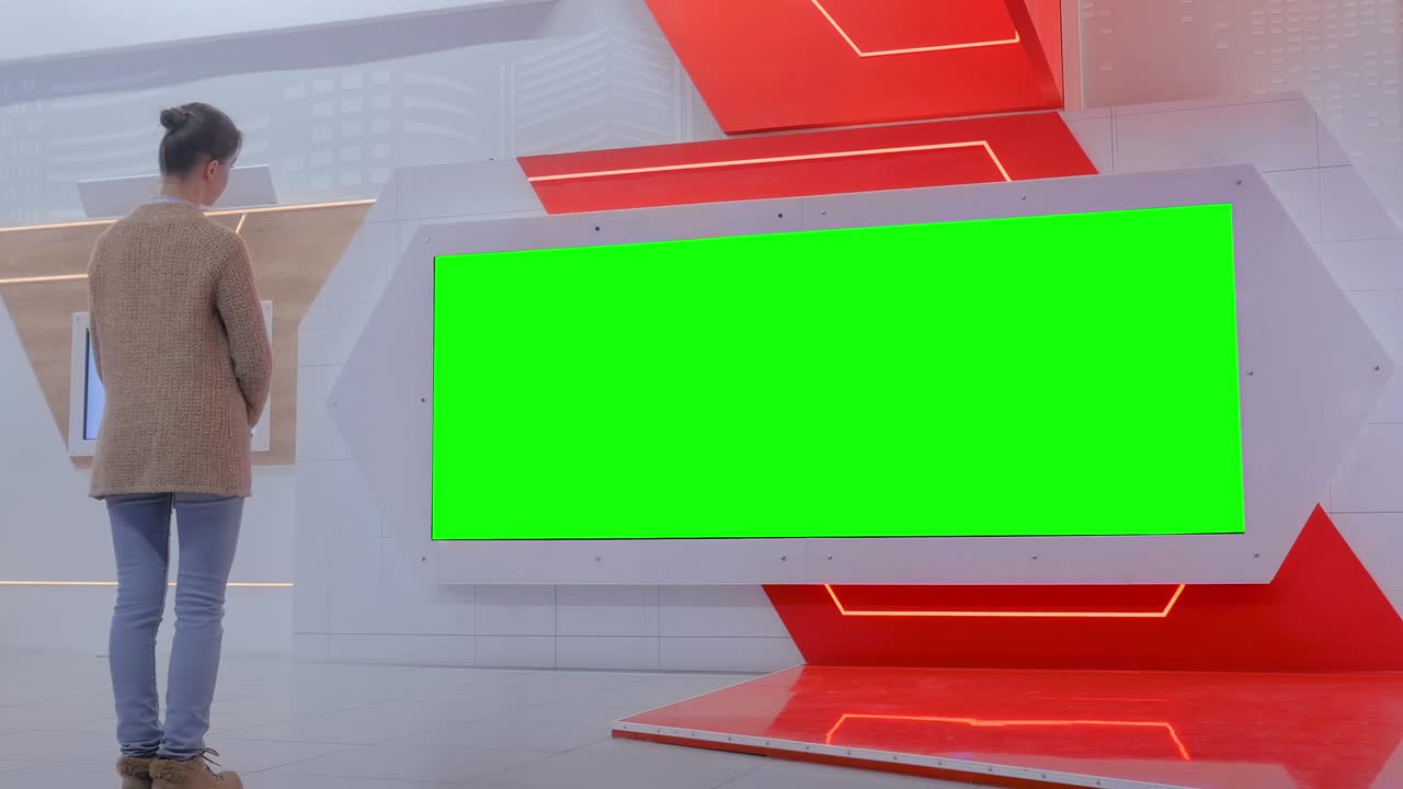 mujer mirando una pantalla de pared interactiva en blanco - concepto de pantalla verde