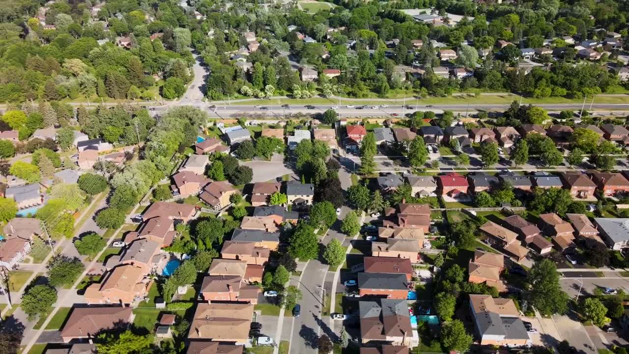 volando sobre casas de mississauga con tráfico en la carretera de abajo