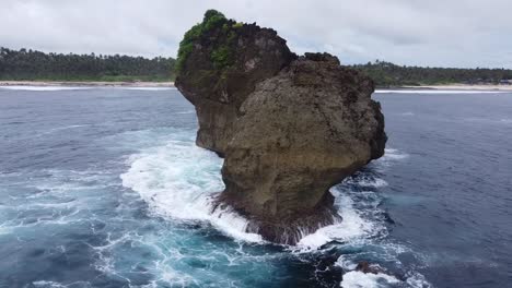 raging ocean waves crashing on coastal sea stack, wearing down rock formation