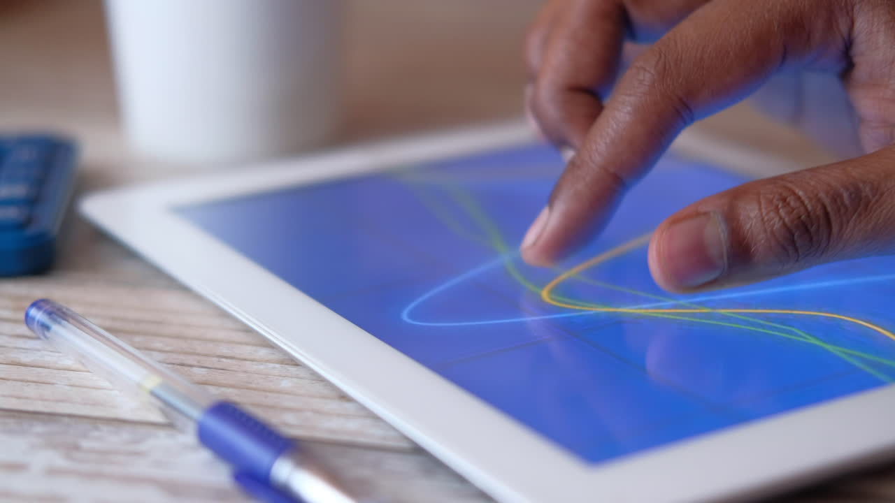 persona que utiliza una tableta para analizar gráficos.