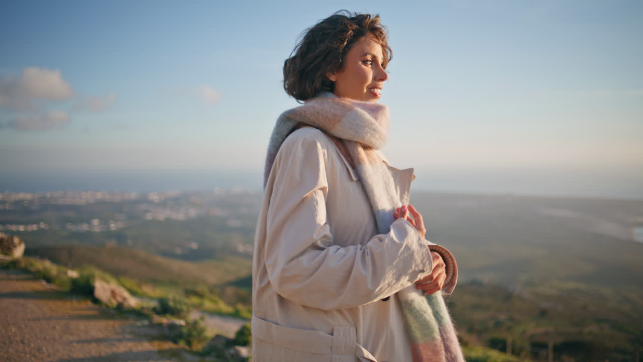 편안한 여자가 해안의 저녁을 상하고 평온함을 느끼고 행복을 가까이서 느니다.