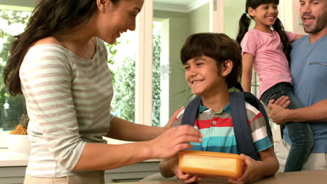 Happy-mother-kissing-her-son-ready-for-school