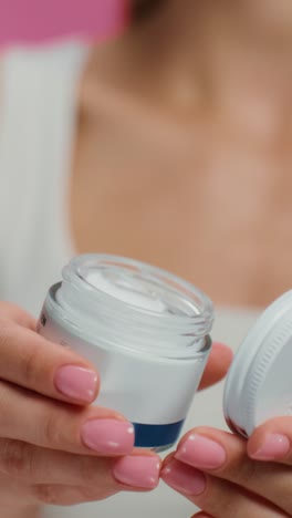 mujer sosteniendo un frasco de crema
