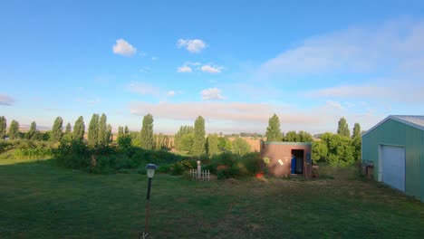 Pan-of-barn,-garden-and-trees-in-late-afternoon-in-eastern-Washington