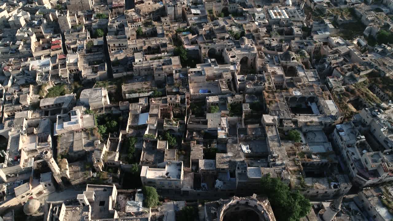 Aerial view with a drone over the rooftops of a district of Aleppo. We can see the roofs of the buildings of the Syrian city under the sunlight 4K