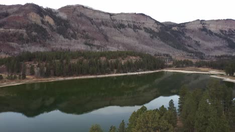 Mountains-with-calm-lake.-Drone-moving-across-lake