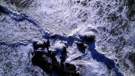 Drone-bird's-eye-push-in-of-waves-and-rock-formations-at-Mavericks-Beach,-California