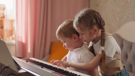 Girl with back braces plays piano hugging toddler blond boy