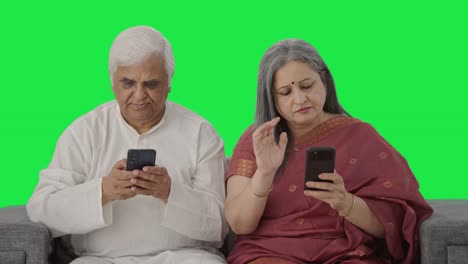 Old-Indian-couple-busy-in-their-phones-Green-screen