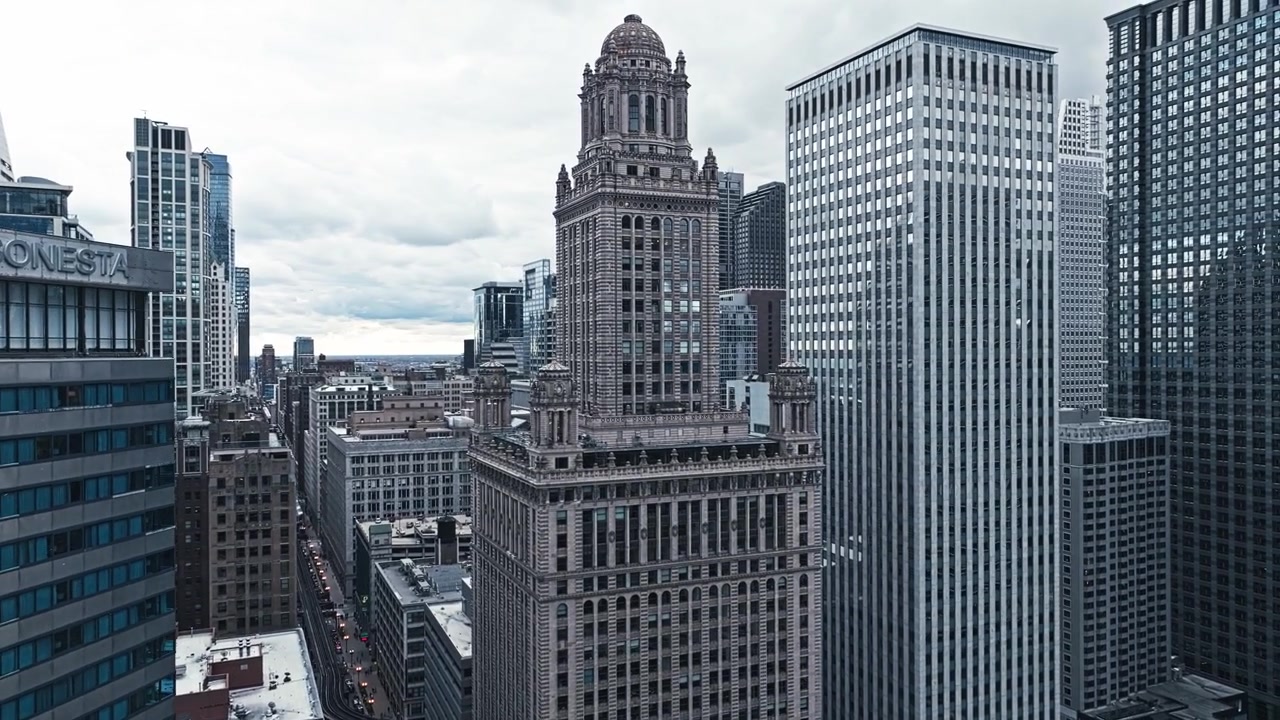 Plano médio aéreo em close-up da histórica Torre de Chicago com sua arquitetura gótica em meio a arranha-céus