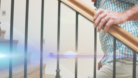 animation of light moving over midsection of senior caucasian man with cane climbing staircase