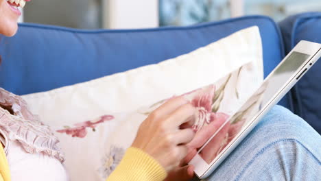 Pretty-brunette-relaxing-on-the-couch-and-using-tablet