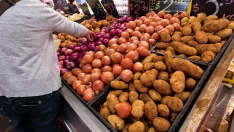 personas seleccionando verduras en el puesto del mercado