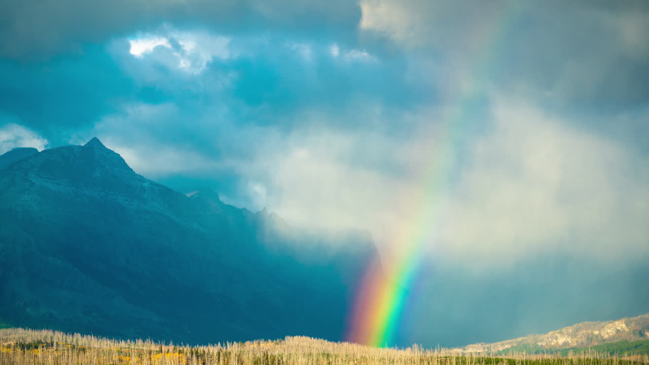 lapso de tiempo del paisaje celestial, arco iris sobre el valle y picos del parque nacional de los glaciares, montana, ee.uu.