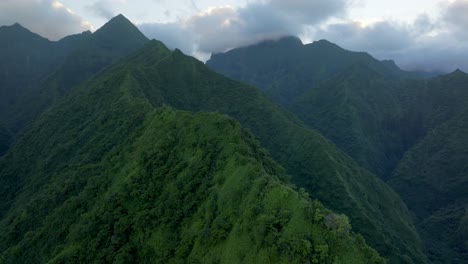 teahupoo tahiti valley high altitude mountain peaks hills sunrise aerial drone view french polynesia yellow clouds golden hour sunset wsl surfing summer olympic venue town village coast backwards pan