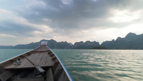 Boat-Ride-In-Cheow-Lan-Lake,-Thailand,-with-Mountain-in-Horizon