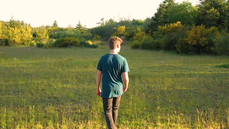niño adolescente siendo inconsciente de la belleza de la naturaleza a su alrededor, caminando y mirando su teléfono inteligente