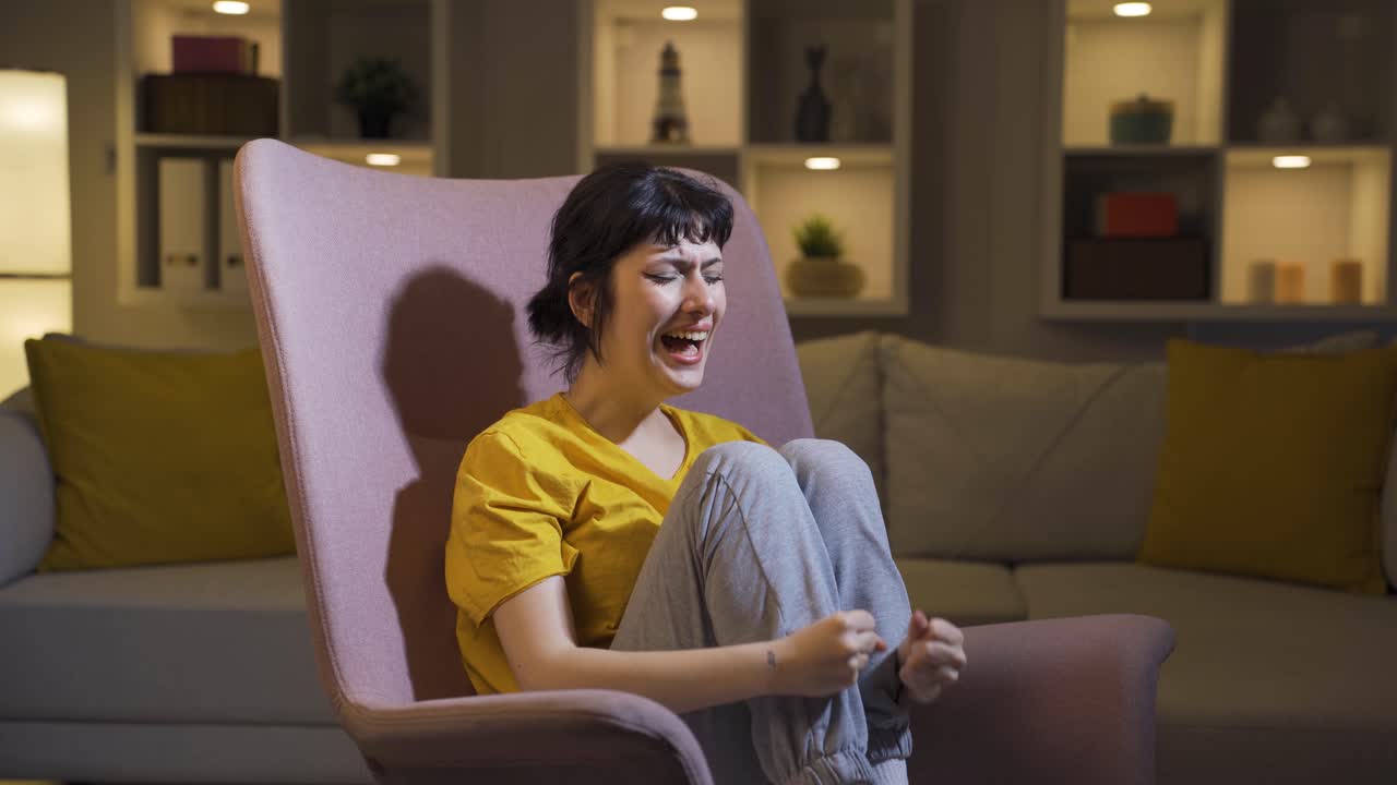 젊은 여자는 집에서 분노로 비명을 지르고 있습니다.
