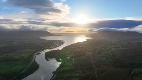flagstaff, county down, northern ireland, november 2022. drone pushes south east towards warrenpoint over the newry river as a golden dawn breaks with carlingford lough and irish sea in the distance.
